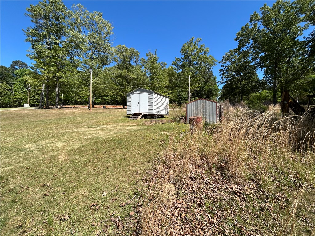 43 Sunset Cove Road Abbeville, SC 29620 - Photo 40 of 41 This spacious yard features mature trees and practical outbuildings, offering versatile outdoor living.