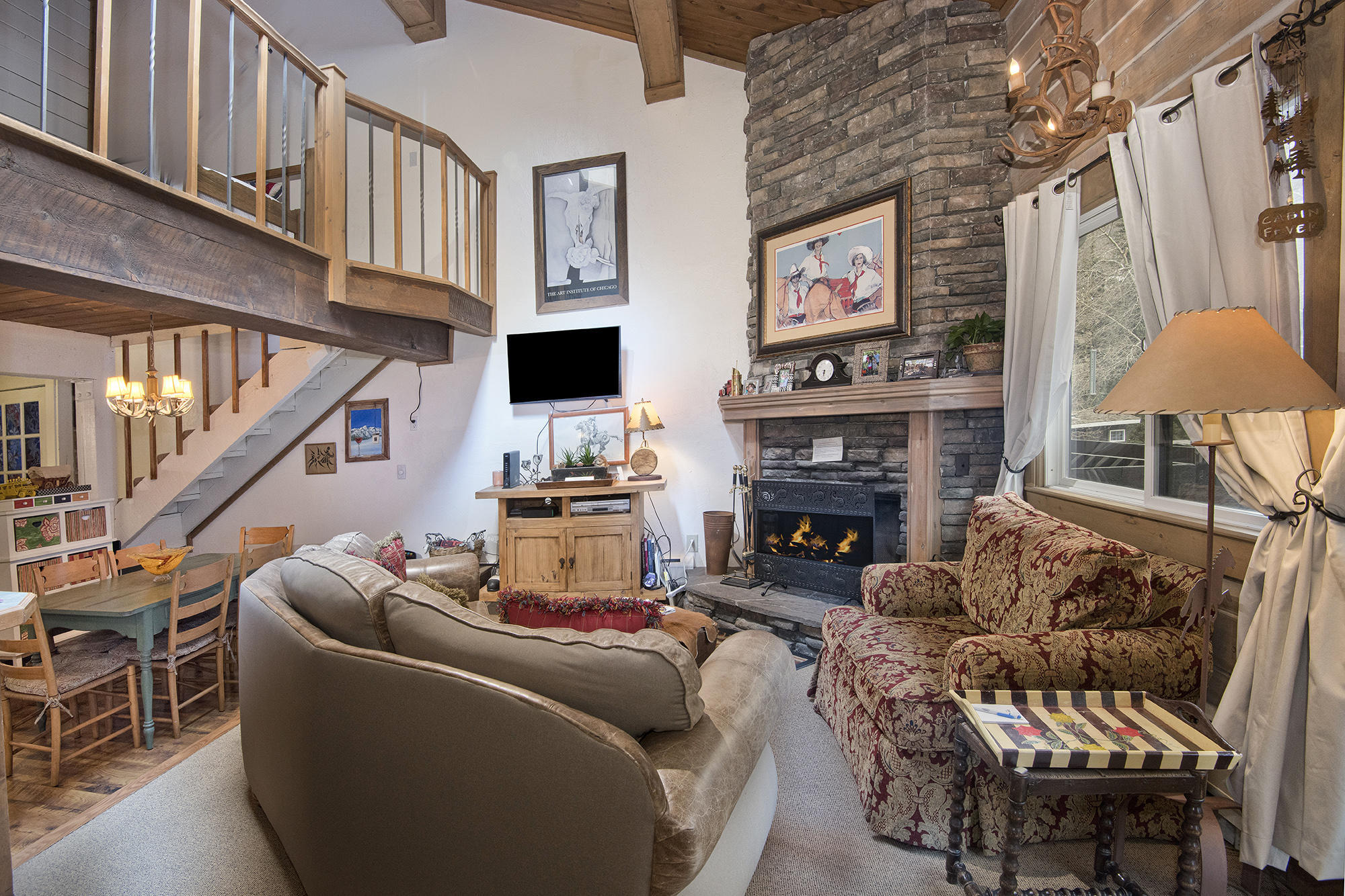 a living room with furniture a fireplace and a large window