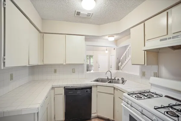 a kitchen with stainless steel appliances granite countertop a sink stove and cabinets