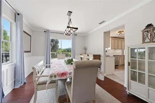 a dining room with furniture a chandelier and wooden floor