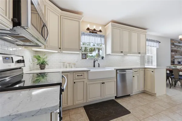 a kitchen with cabinets appliances and a window