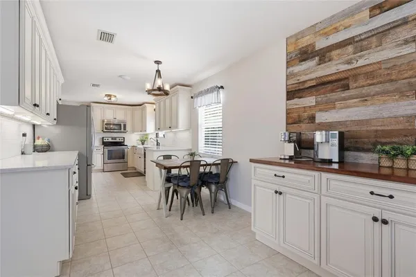 a kitchen with cabinets and chairs