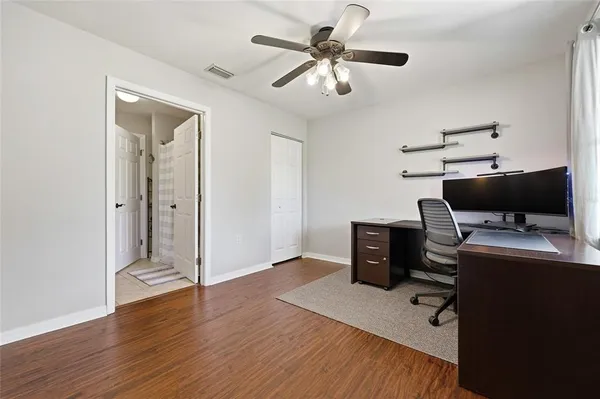 a view of workspace with wooden floor and ceiling fan