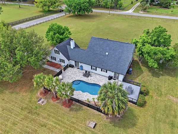 an aerial view of a house with swimming pool and outdoor space