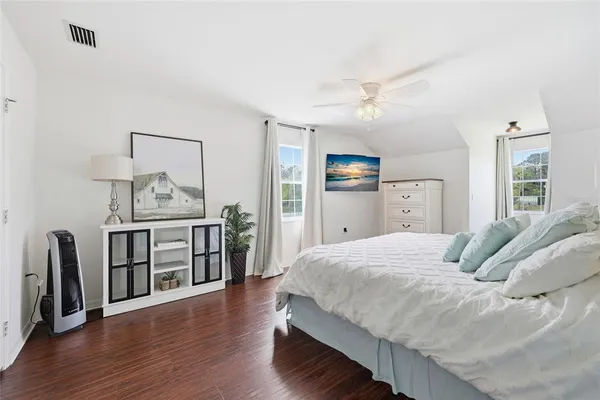 a bedroom with a bed and wooden floor