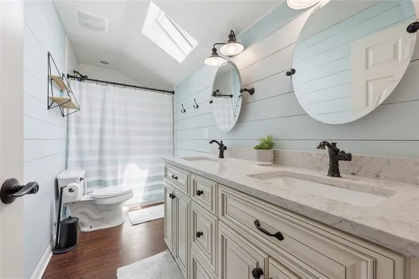 a bathroom with a double vanity sink mirror and toilet