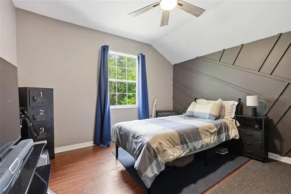 a bedroom with a bed and wooden floor