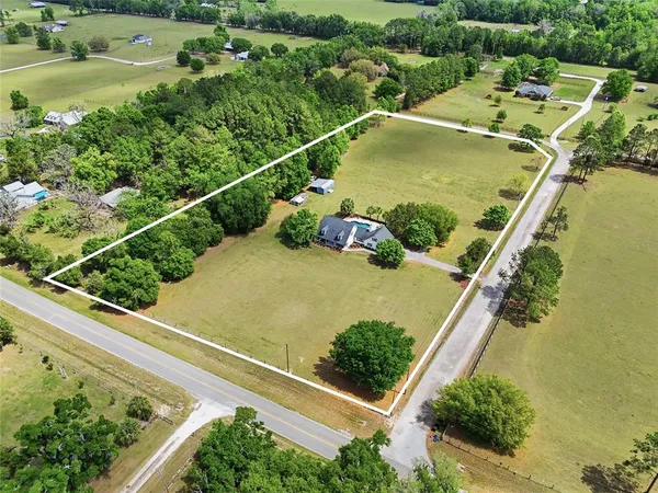an aerial view of a residential houses with outdoor space and street view