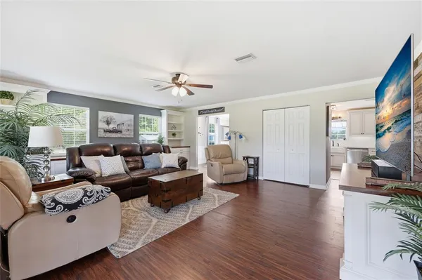 a living room with furniture flat screen tv and a large window
