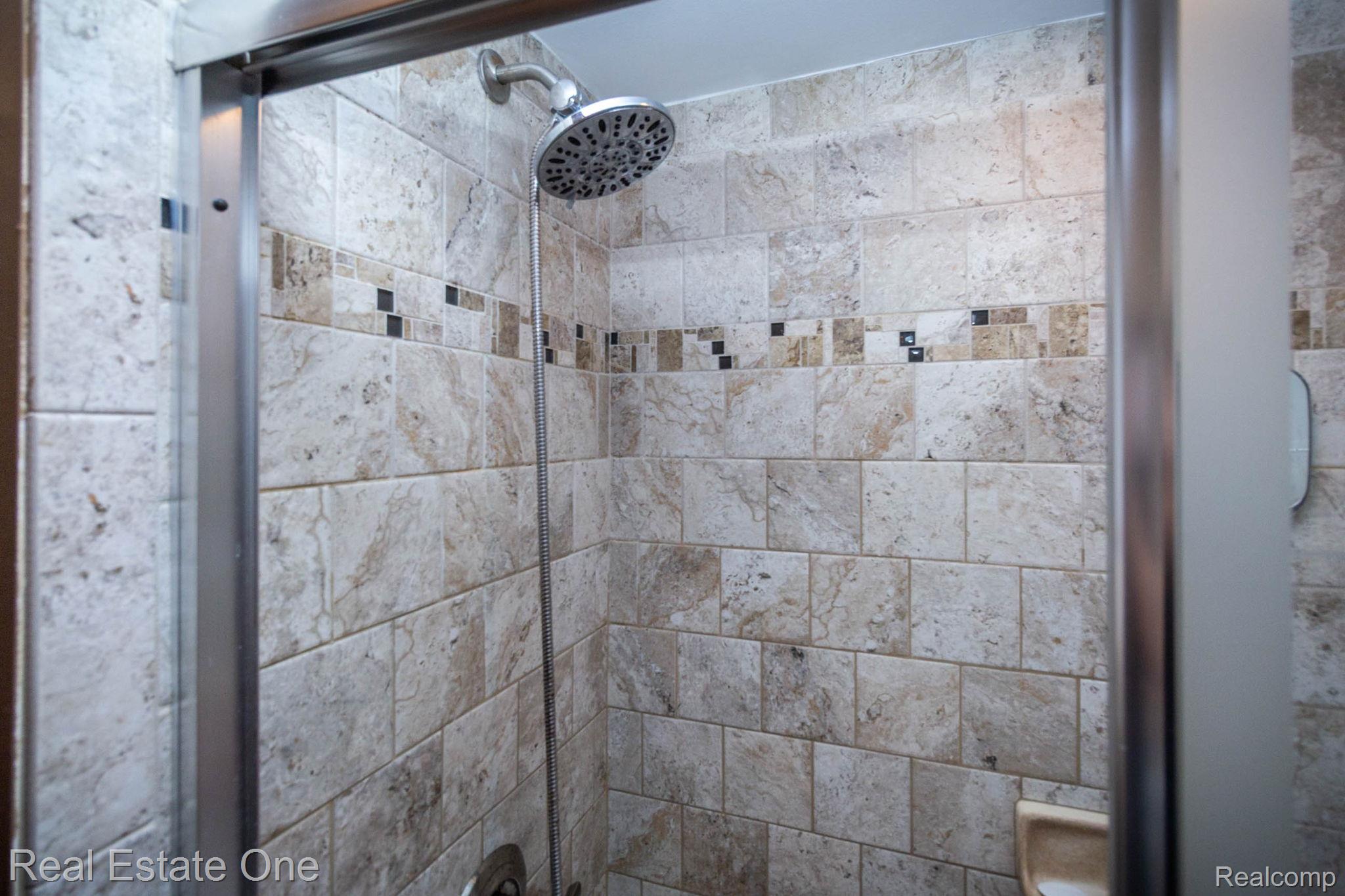 220 Winry Drive Rochester, MI 48307 - Photo 18 of 35 Shower enclosure featuring a multi-tone tiled surround with decorative accent band