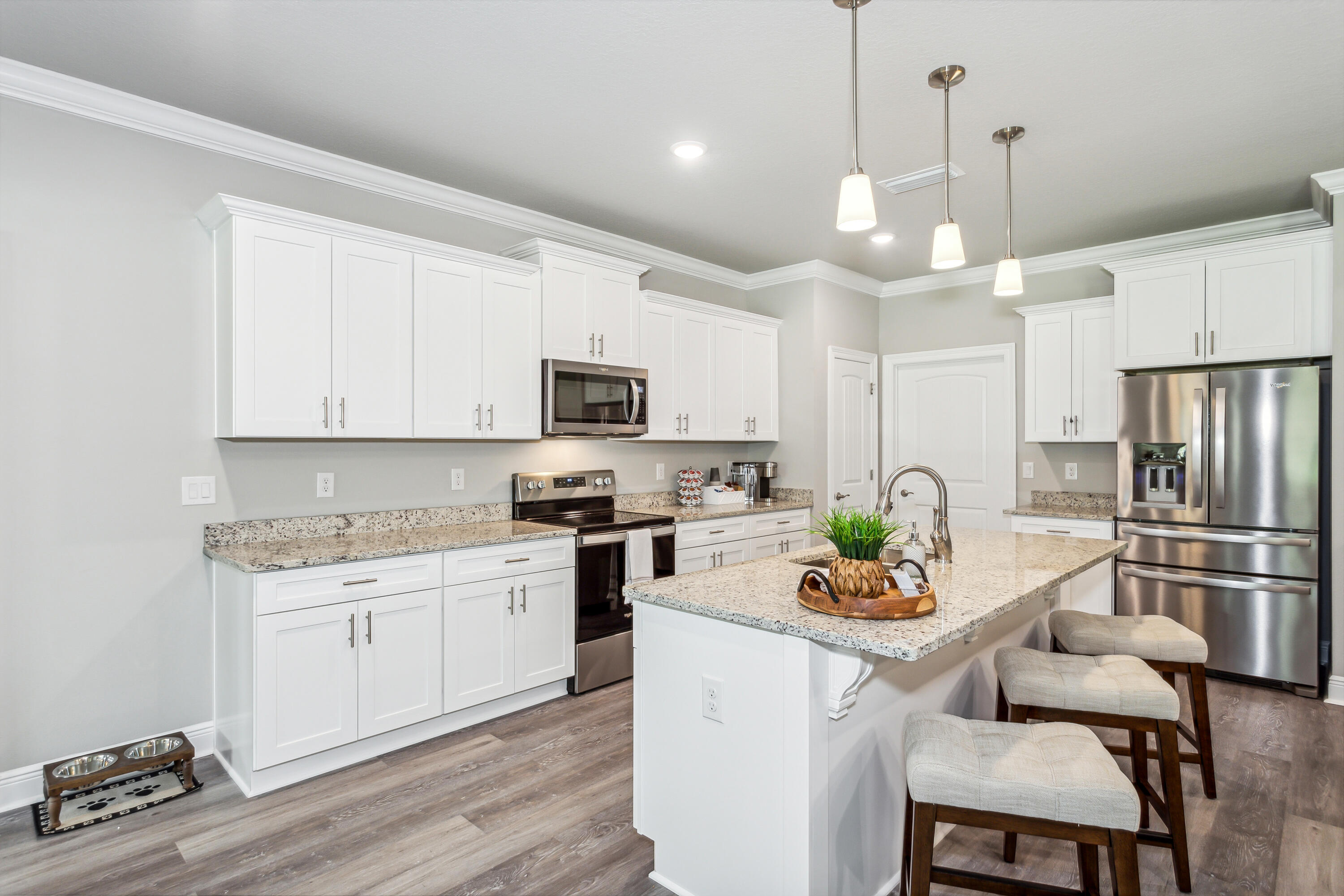 8721 Valhalla Drive Milton, FL 32583 - Photo 15 of 48 a kitchen with white cabinets and stainless steel appliances
