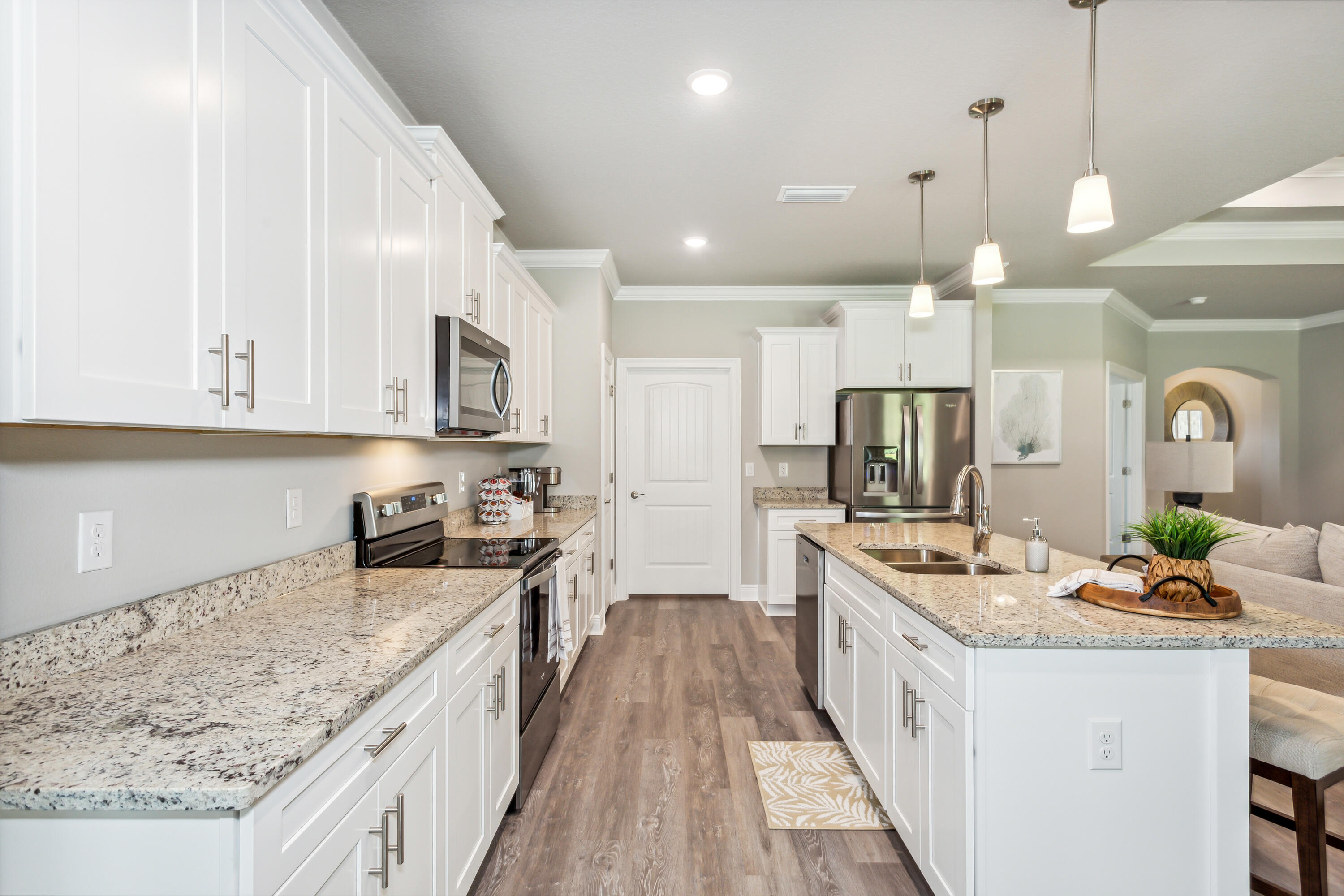 8721 Valhalla Drive Milton, FL 32583 - Photo 16 of 48 a kitchen with stainless steel appliances kitchen island granite countertop a large stove a sink dishwasher and a microwave oven with white cabinets