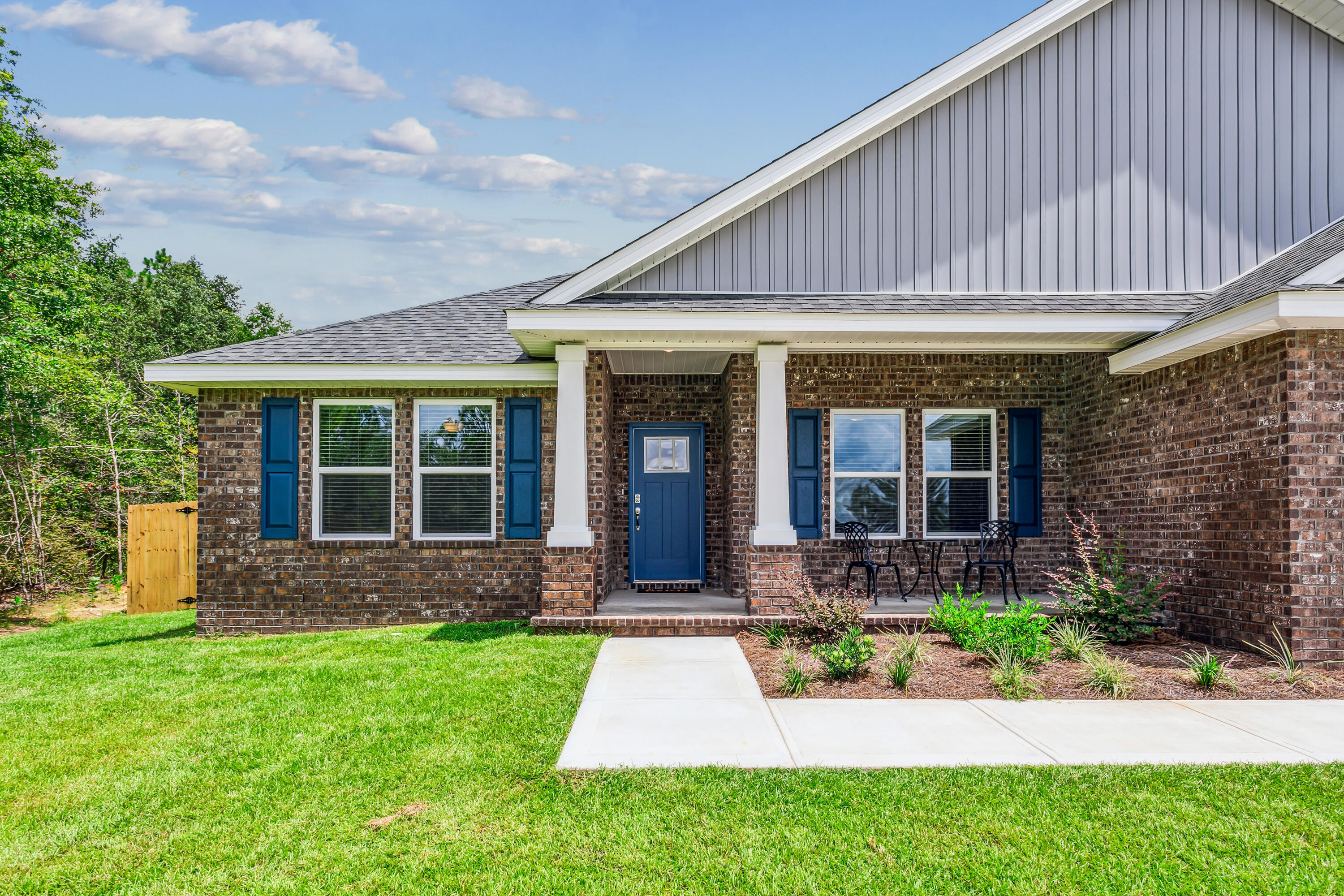 8721 Valhalla Drive Milton, FL 32583 - Photo 4 of 48 a view of brick house with a large windows plants and large trees