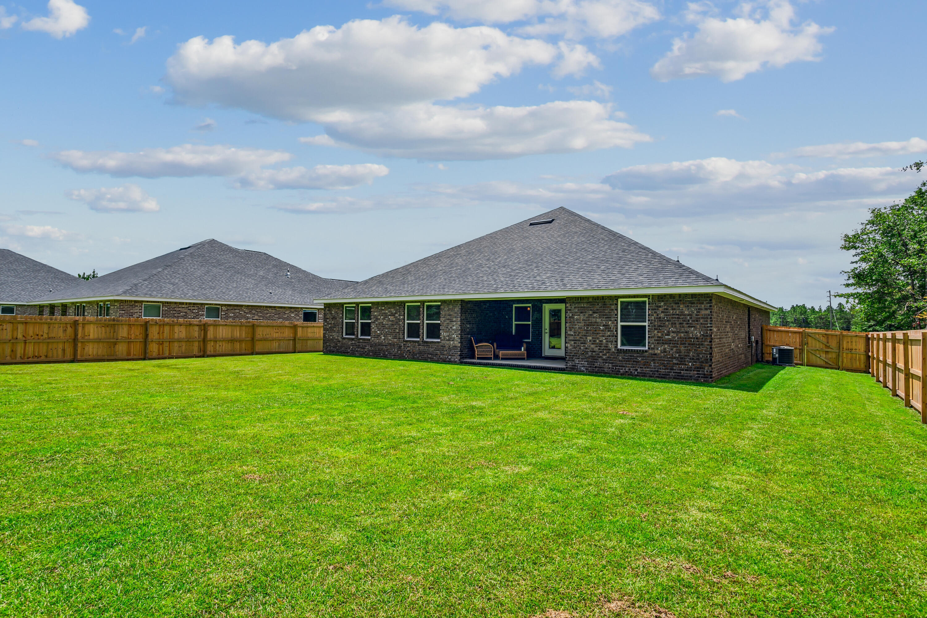 8721 Valhalla Drive Milton, FL 32583 - Photo 47 of 48 a view of a big house in front of a big yard with plants and wooden fence