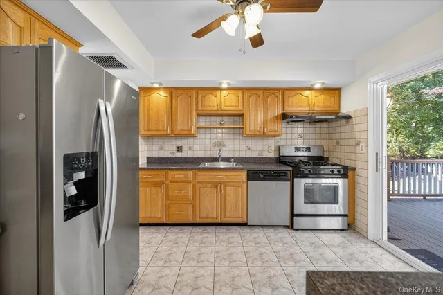 a kitchen with stainless steel appliances granite countertop a stove a refrigerator and a sink