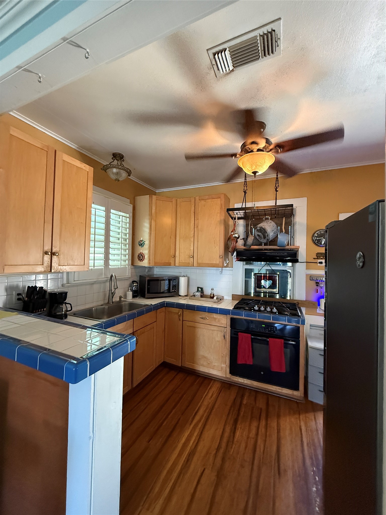 4416 Avenue R Galveston, TX 77550 - Photo 8 of 11 a kitchen with granite countertop a stove cabinets and wooden floor