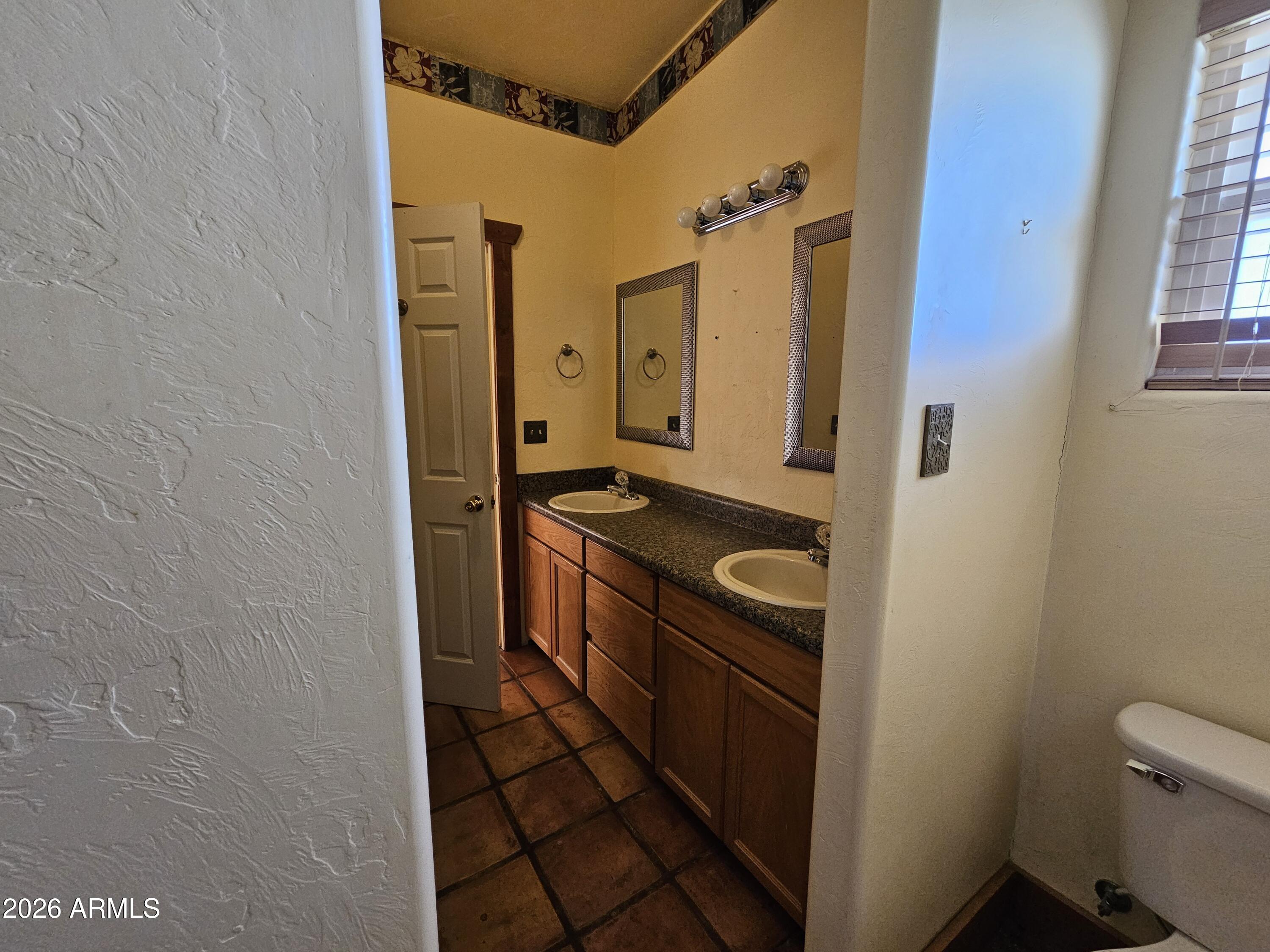 4105 North Washington Avenue Douglas, AZ 85607 - Photo 34 of 61 a bathroom with a granite countertop sink and a washing machine