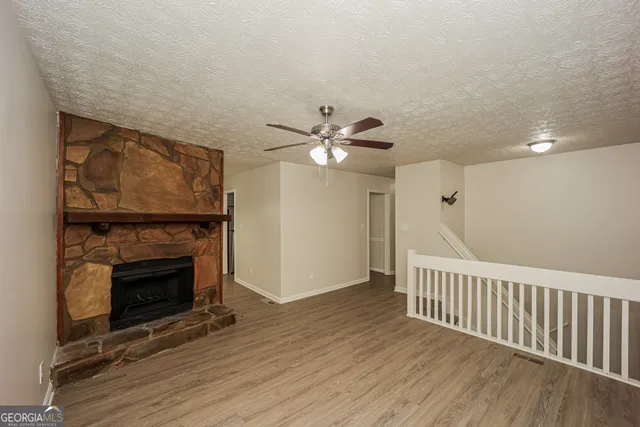 a view of a livingroom with wooden floor and a fireplace
