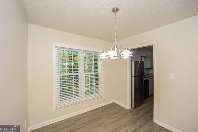 a view of a livingroom with a chandelier a fireplace and wooden floor