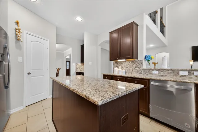 a kitchen with stainless steel appliances granite countertop a sink and a refrigerator
