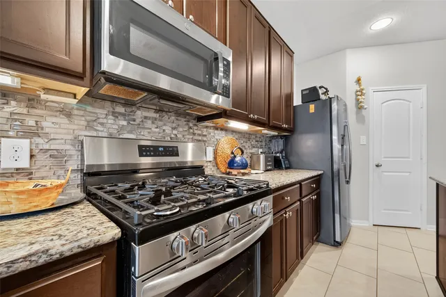 a kitchen with stainless steel appliances granite countertop a stove and a refrigerator