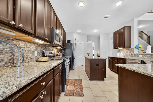 a large kitchen with granite countertop lots of counter space and a sink
