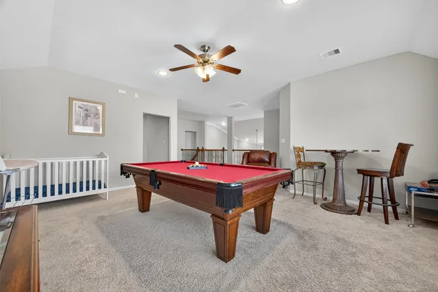 a room with pool table and windows
