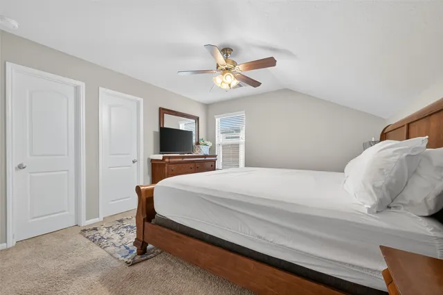a bedroom with a bed and a flat tv screen on dresser