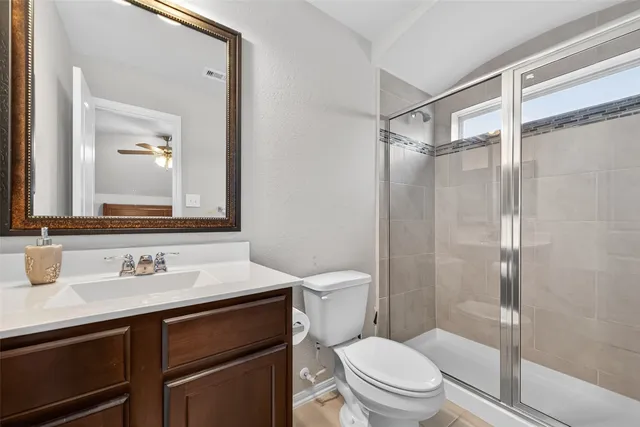 a bathroom with a sink toilet vanity and shower