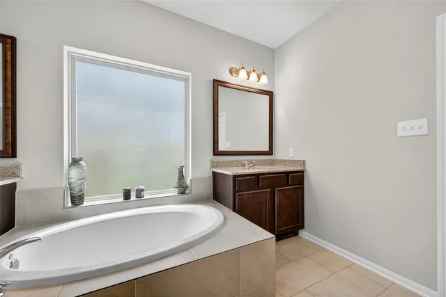 a bathroom with a bathtub sink and mirror