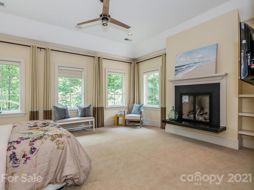 8424 Eagle Glen Charlotte, NC 28210 - Photo 38 of 48 a spacious bedroom with a bed and a fireplace