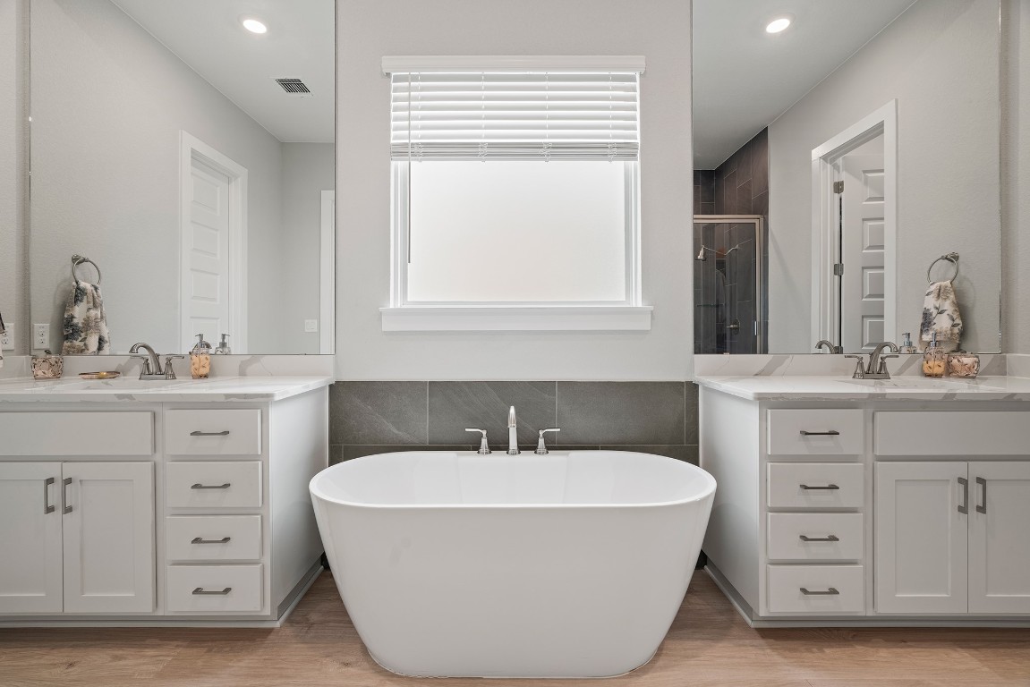 2112 Tobiano Trace Georgetown, TX 78633 - Photo 21 of 40 a bathroom with a tub sink double vanity and mirror