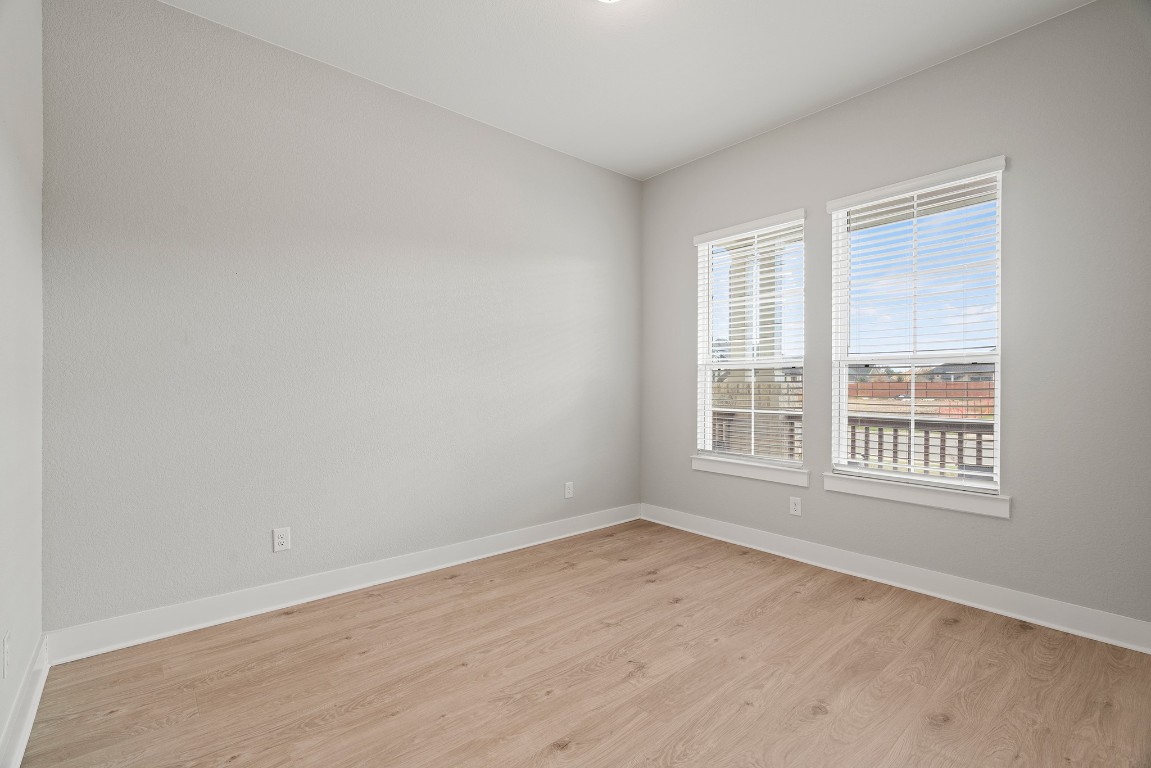 2112 Tobiano Trace Georgetown, TX 78633 - Photo 22 of 40 an empty room with wooden floor and windows