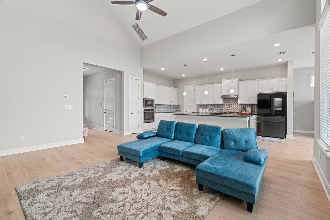 2112 Tobiano Trace Georgetown, TX 78633 - Photo 7 of 40 a large living room with stainless steel appliances kitchen island granite countertop a couch and a view of living room