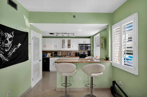 a kitchen with granite countertop a stove a sink and a microwave
