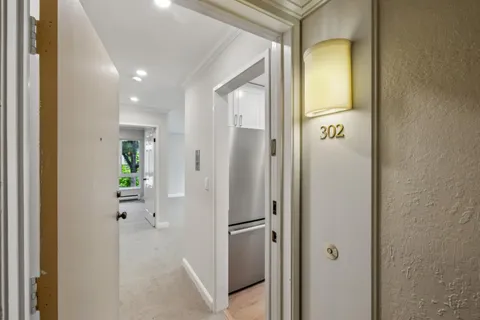 a view of a hallway with wooden floor and staircase