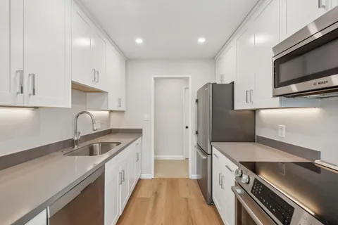 a kitchen with stainless steel appliances granite countertop a sink stove and refrigerator
