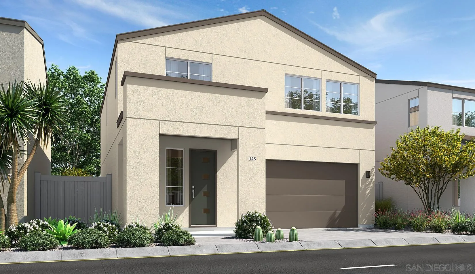 a front view of a house with garage and plants