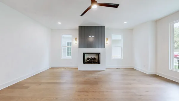 an empty room with windows and fireplace