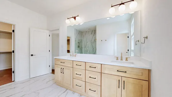 a bathroom with a granite countertop double vanity sink mirror and