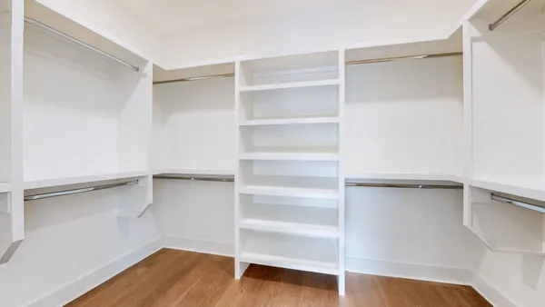 a view of walk in closet with empty racks