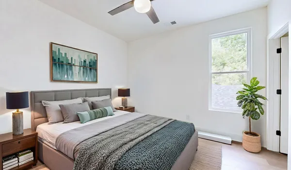 a bedroom with bed and a potted plant