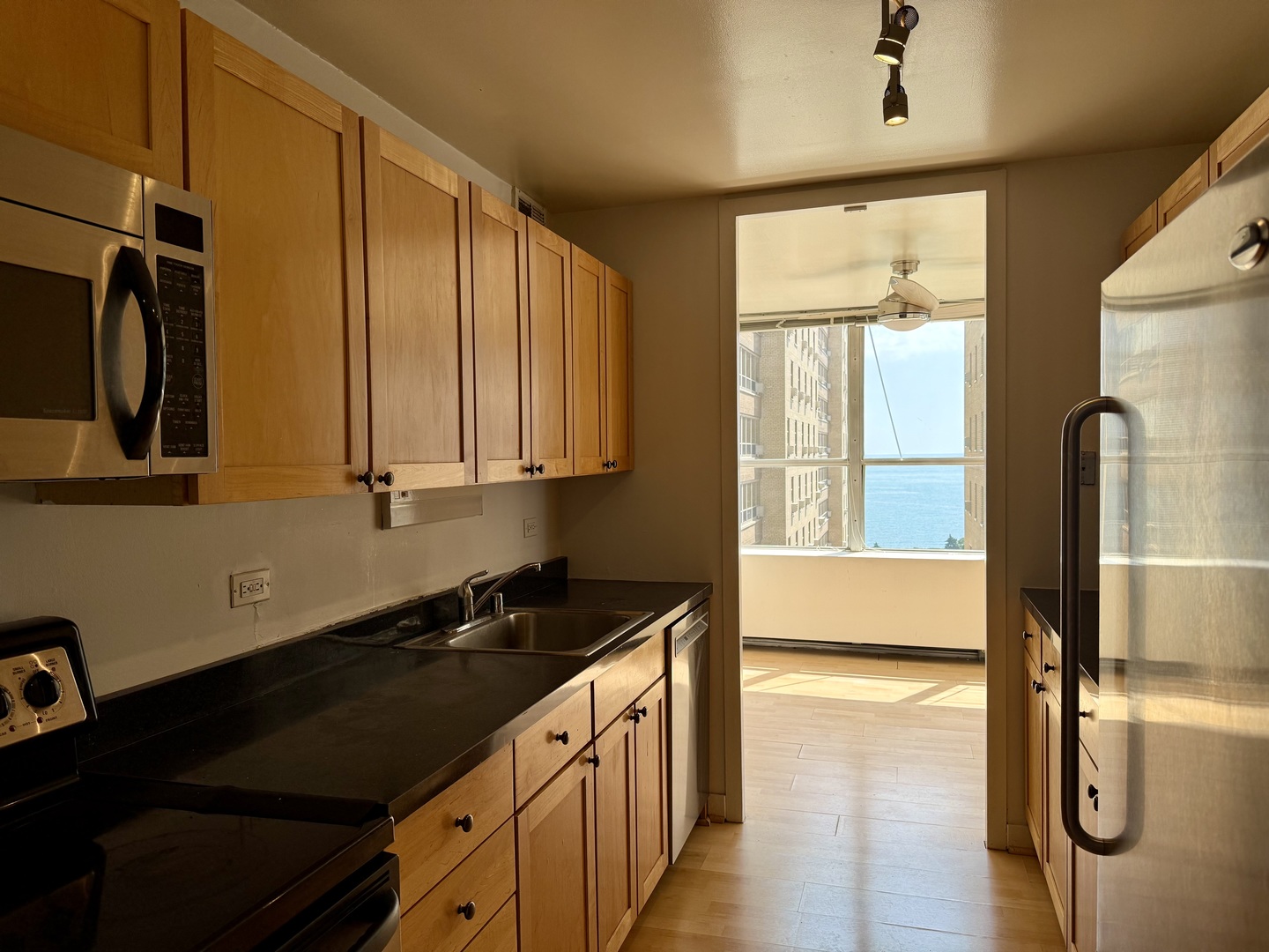 655 West Irving Park Road, Unit 1801 Chicago, IL 60613 - Photo 3 of 35 a kitchen with stainless steel appliances granite countertop a sink and a refrigerator