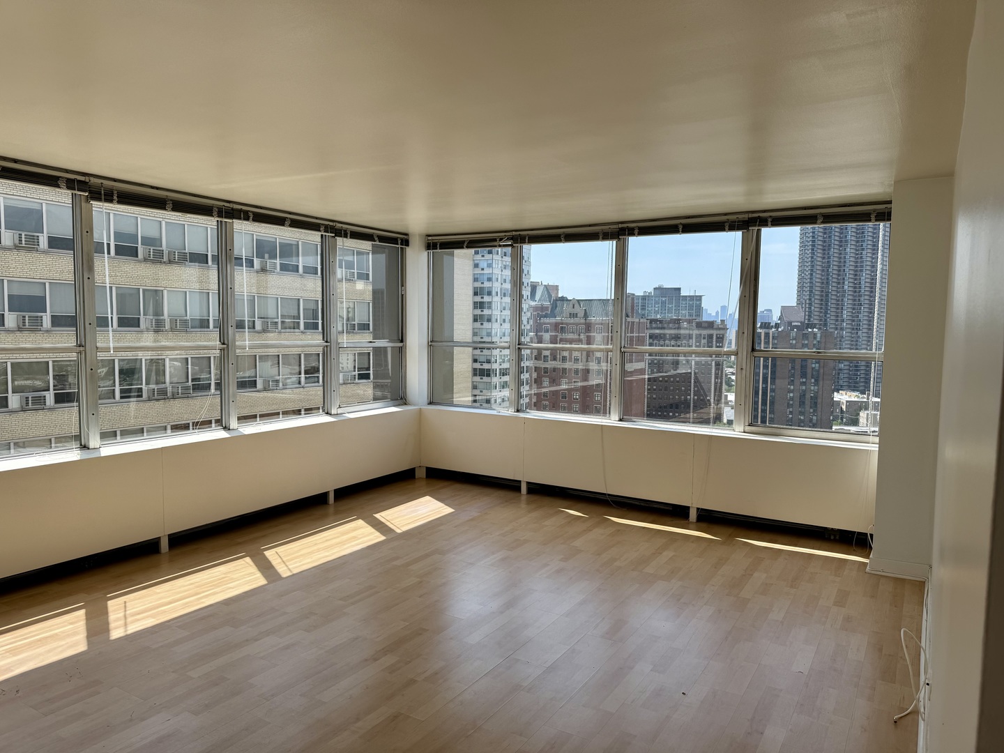 655 West Irving Park Road, Unit 1801 Chicago, IL 60613 - Photo 8 of 35 a view of an empty room with wooden floor and a window