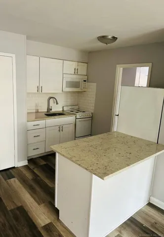 a kitchen with a sink a stove and cabinets