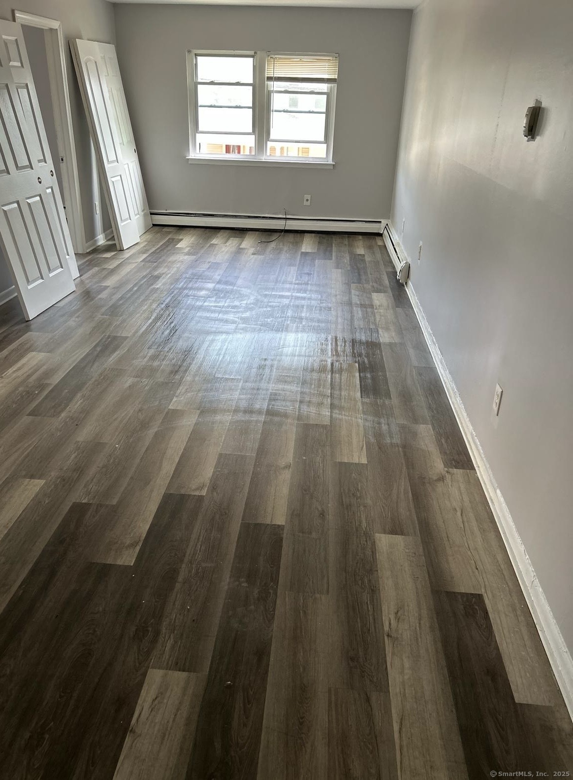 80 Taft Avenue, Unit 7 Bridgeport, CT 06606 - Photo 2 of 3 wooden floor in an empty room with a window