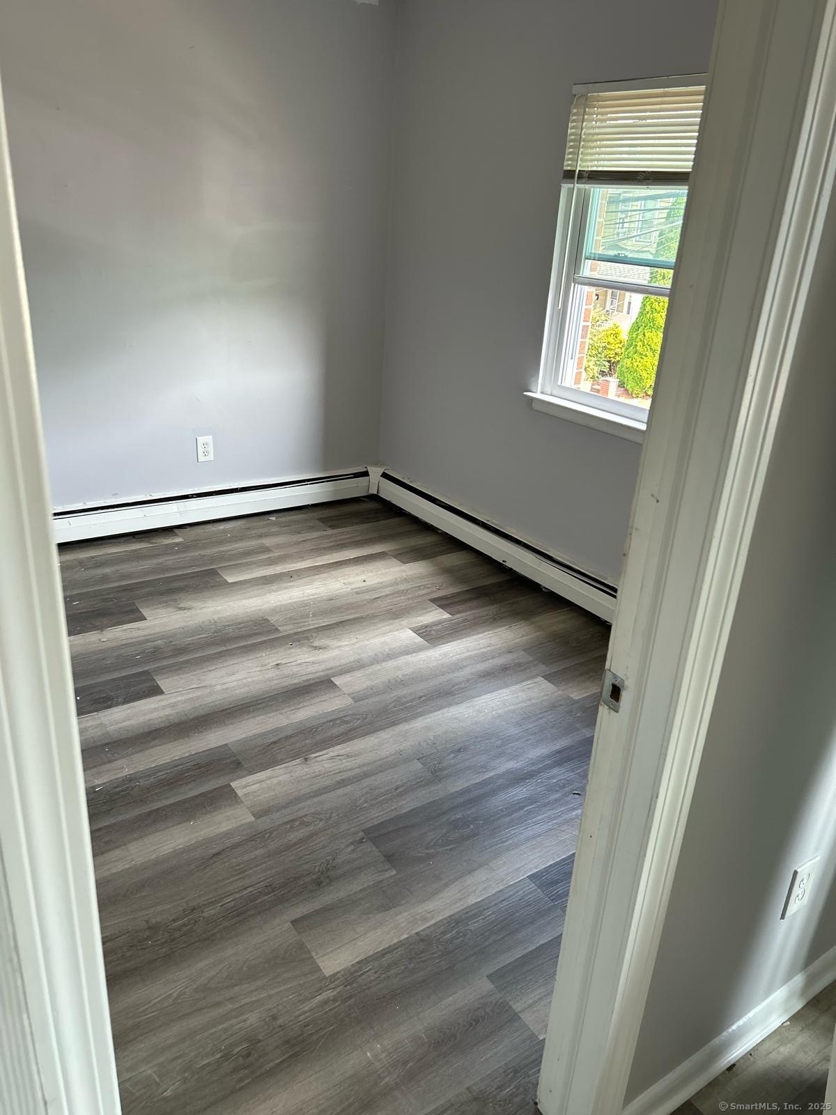 80 Taft Avenue, Unit 7 Bridgeport, CT 06606 - Photo 3 of 3 a view of an empty room with wooden floor and a window