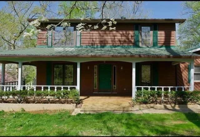 a front view of a house with yard and outdoor seating