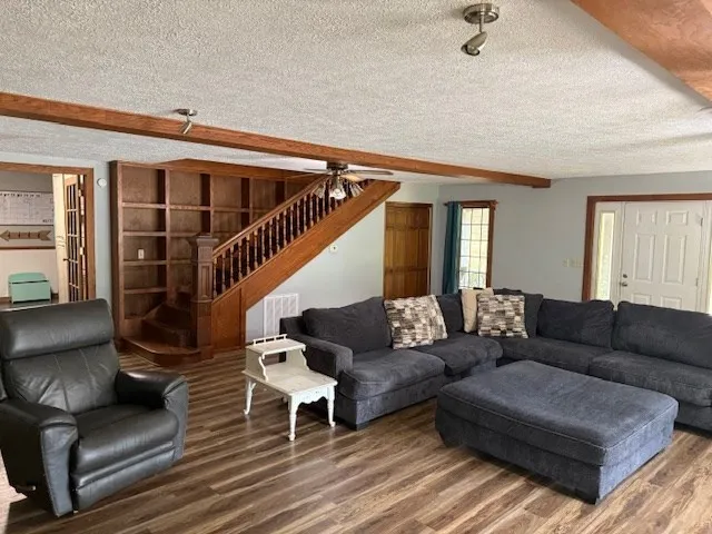 a living room with furniture and a wooden floor