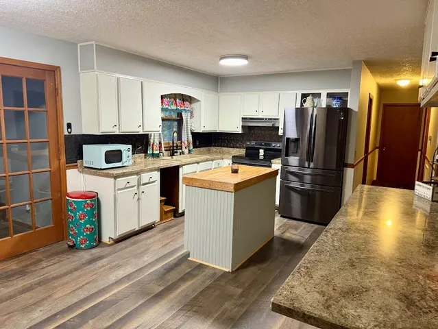 a kitchen with stainless steel appliances granite countertop a stove a sink and a refrigerator
